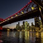 Large bridge at night overlooking large city, bright lights