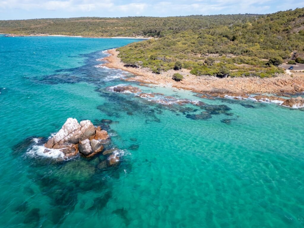 Large rock in ocean, bright blue water