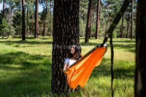 Nakie Hammock in pine forest, girl in hammock with white shirt, dark hair