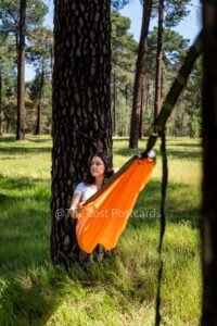 Nakie Hammock in pine forest, girl in hammock with white shirt, dark hair