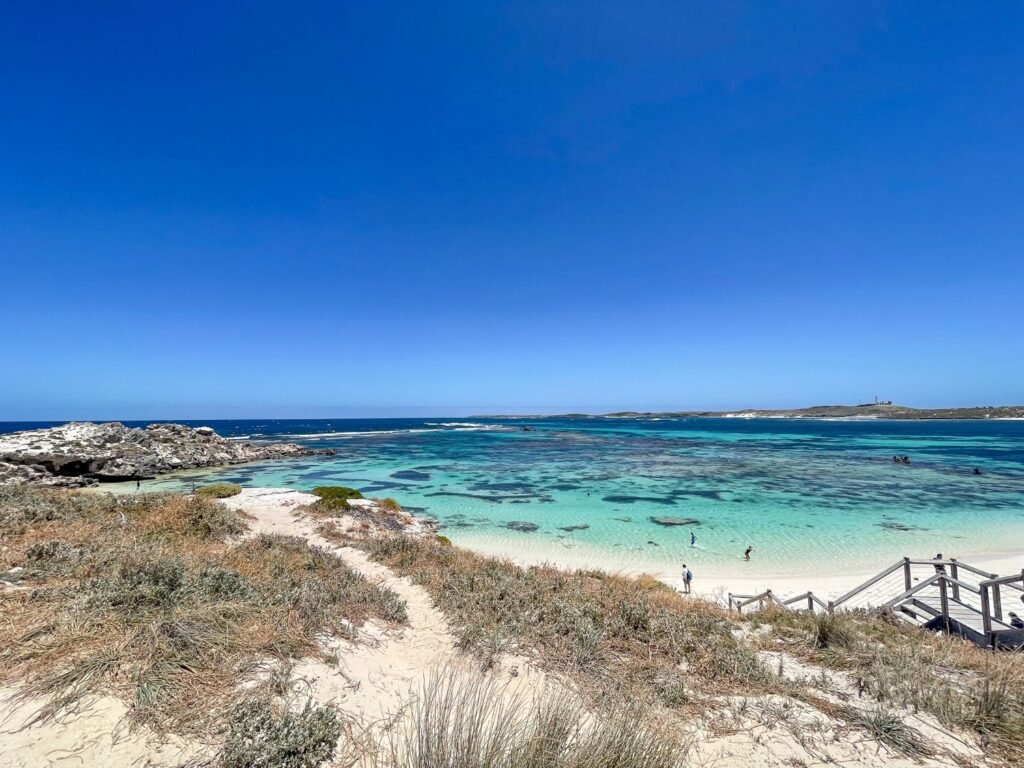 Beautiful blue beach, white sand, stairs leading down to beach