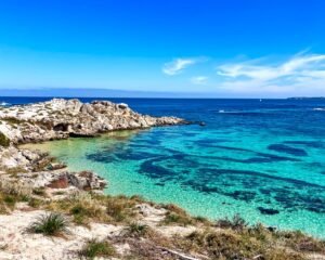 Beautiful bright blue beach, small cliffs in background, Rottnest Island