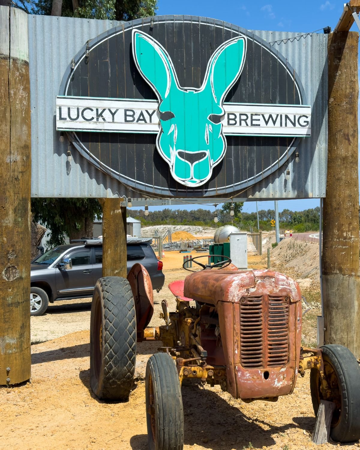 Big sign with old tractor undernearh, sign reads Lucky Bay Brewing